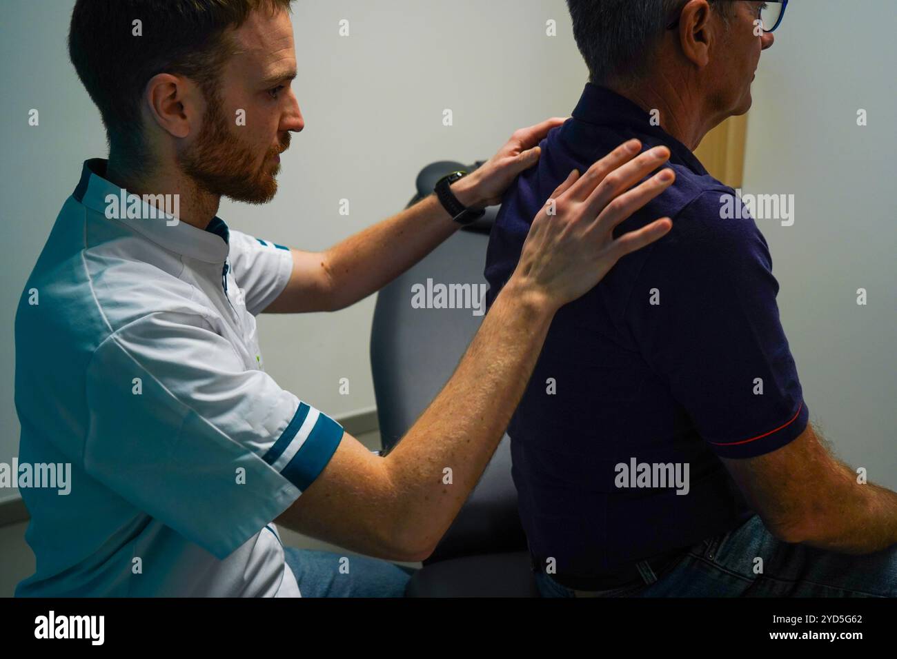 Physiotherapy center specializing in shoulder pathology before or after operation. Shoulder rehabilitation session. Search for the trigger point. Stock Photo