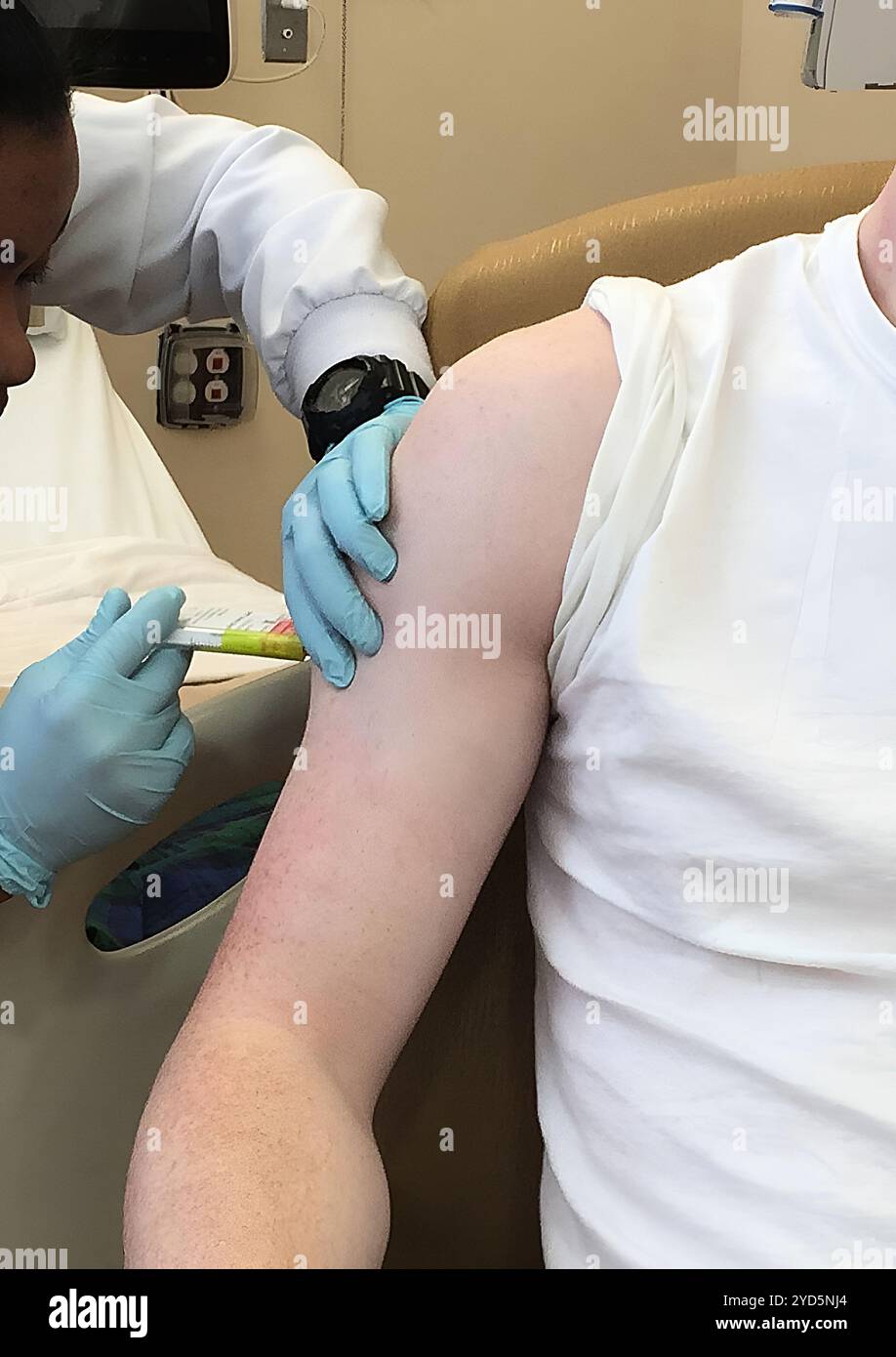 A participant receives an injection in an NIH trial examining a vaccine intended to provide broad protection against a range of mosquito-borne. Stock Photo