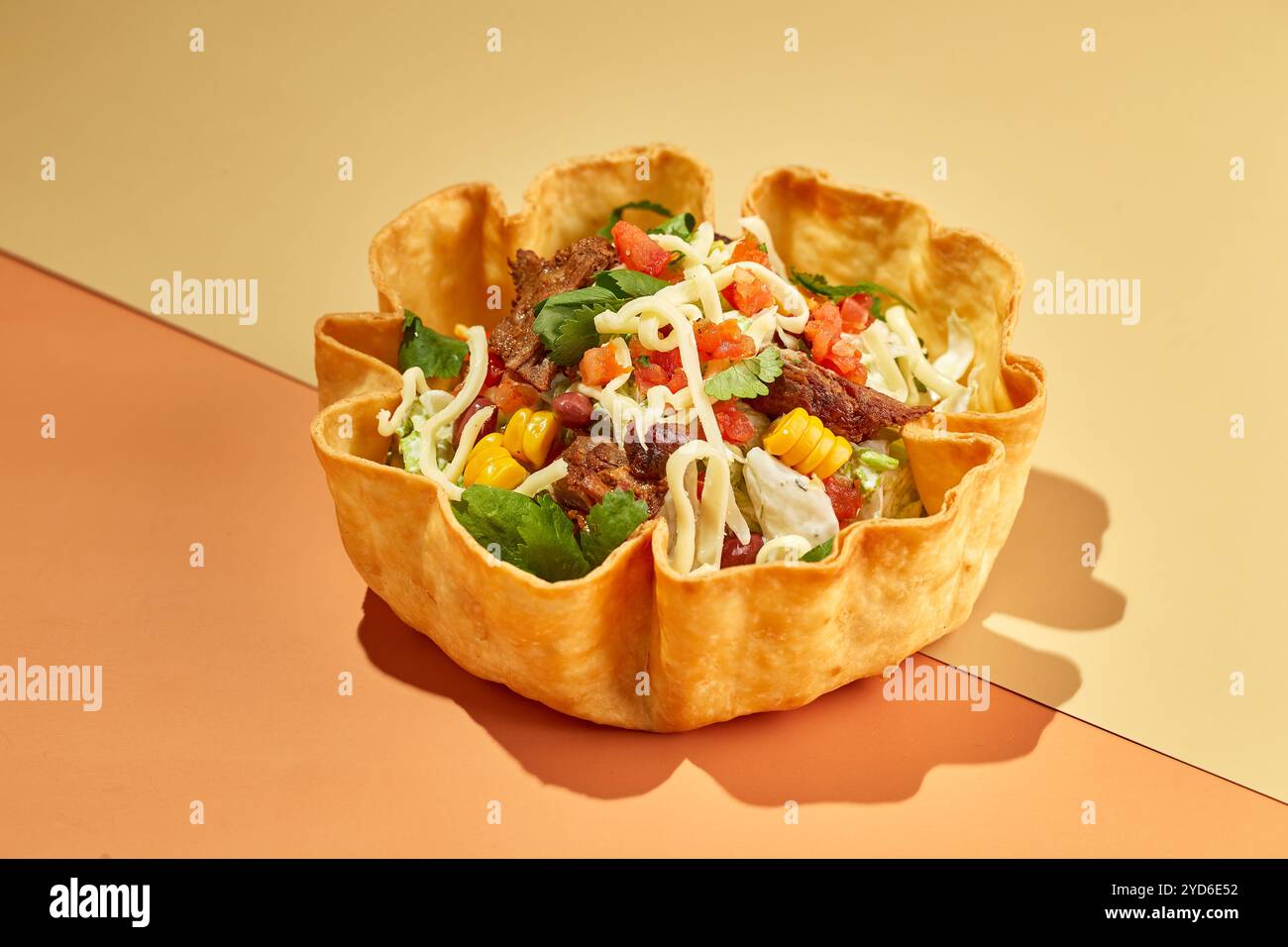 Taco salad in tortilla bowl with beef, cheese, corn and lettuce Stock Photo