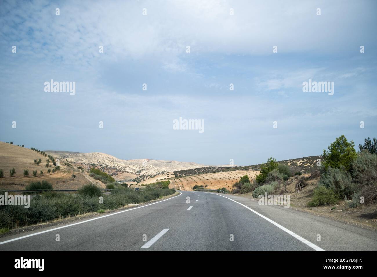 Road in the middle of a country landscape with agricultural fields on a hill near Meknes in Morocco on 31 October 2023. Route au milieu d un paysage d Stock Photo