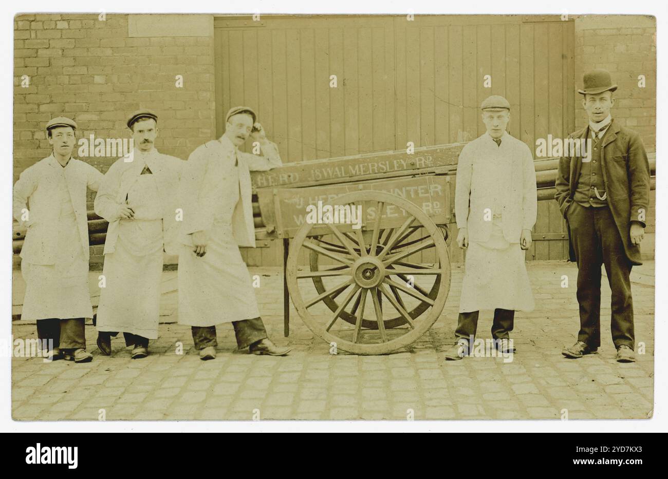 Original early 1900's Edwardian era, circa 1910's  postcard of team of painters / tradesmen /workmen with cart. The  sign on the cart is  J. Herd Walmersley road, Bury, painter. The proprietor standing next to the men is probably  James Herd, painter who is listed in Kelly's directory 1924.Bury, Greater Manchester, England, U.K. Stock Photo