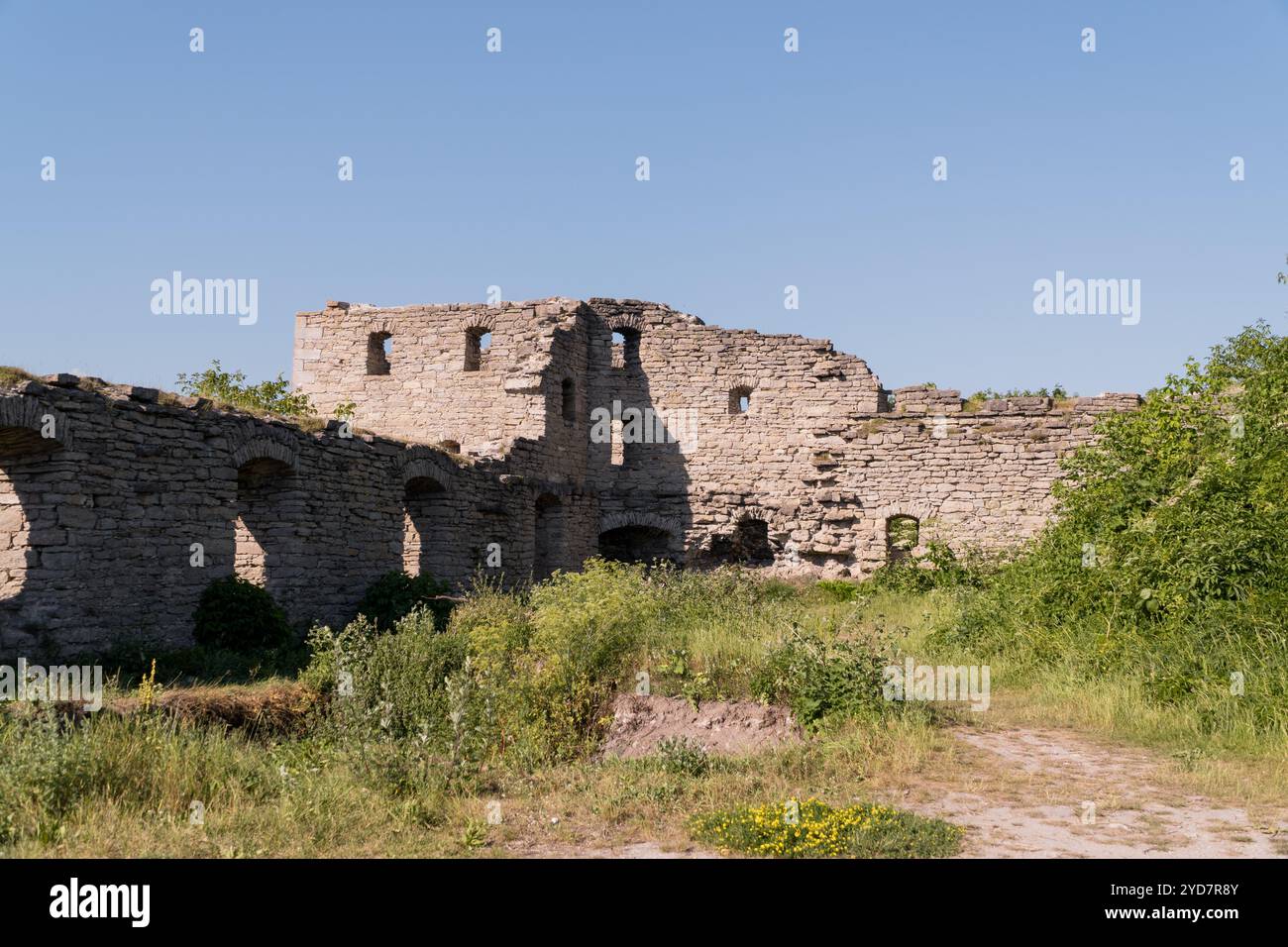 Ancient Stone Ruins Overgrown with Vegetation Under Clear Blue Sky ...