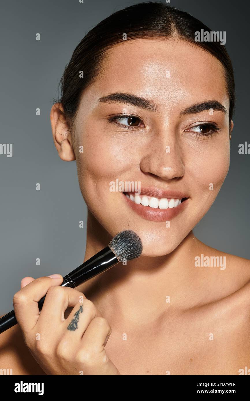 A joyful woman enhances her features with a brush, embracing her unique charm and elegance. Stock Photo