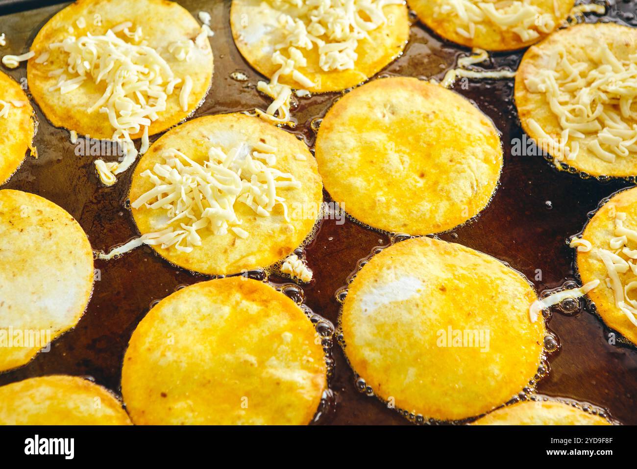 Frying tacos tortillas with cheese on griddle in professional kitchen in restaurant. Mexican cuisine, Latin American fast food Stock Photo