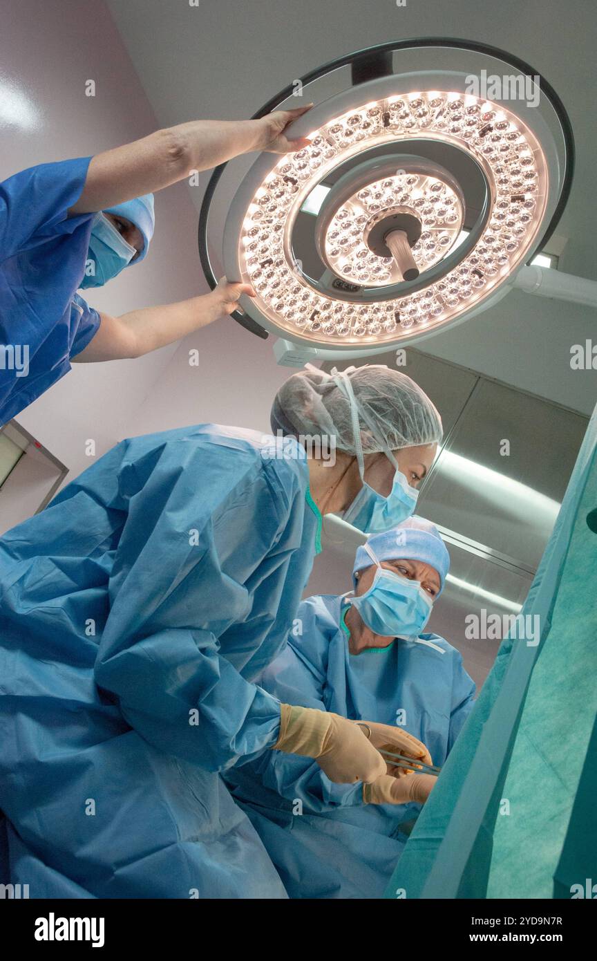 A surgical team working together in an operating room, with the surgeon ...