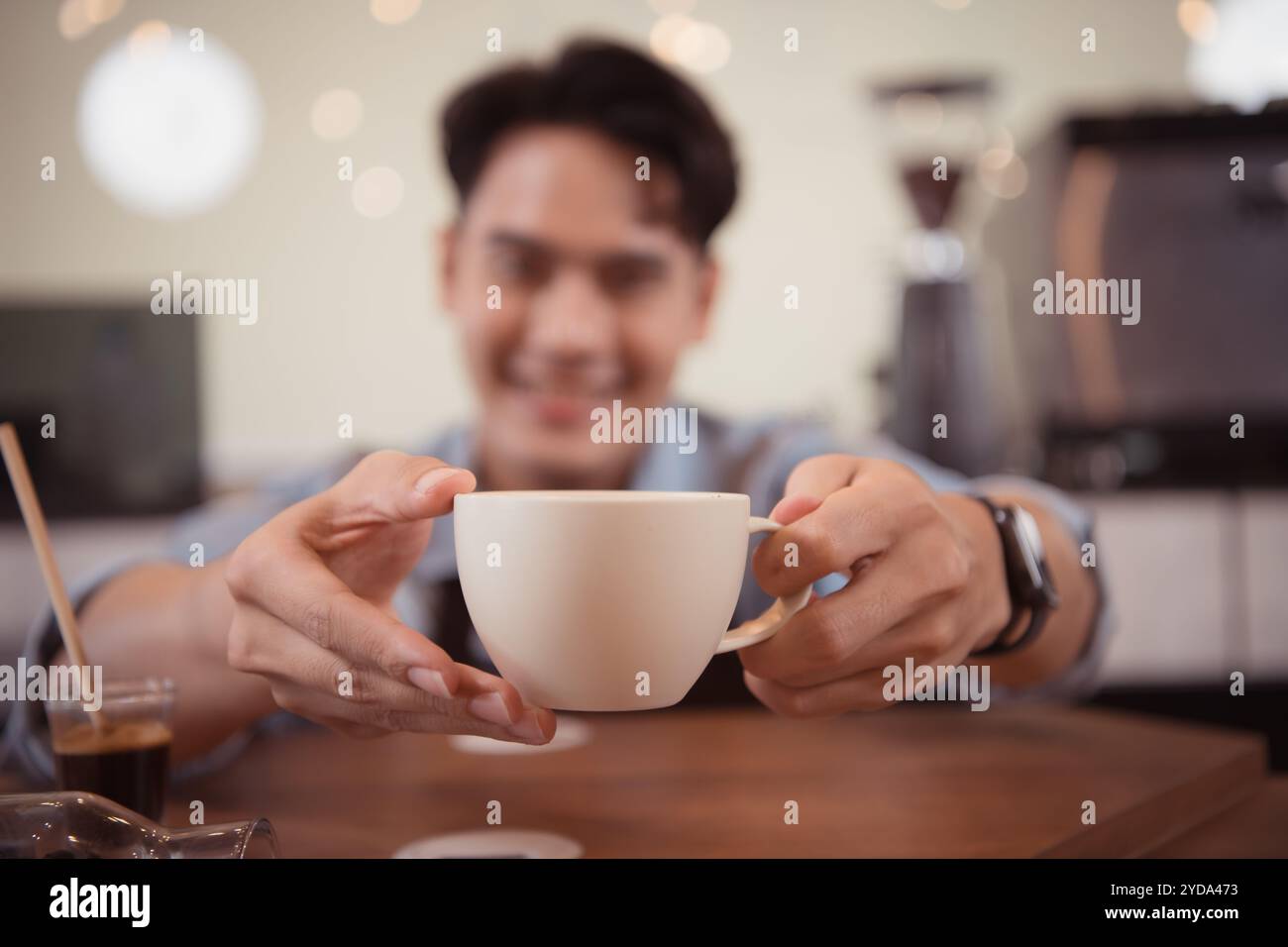 Young barista with the intention of making up a latte coffee to satisfy customers both in appearance and taste, This cup of coff Stock Photo