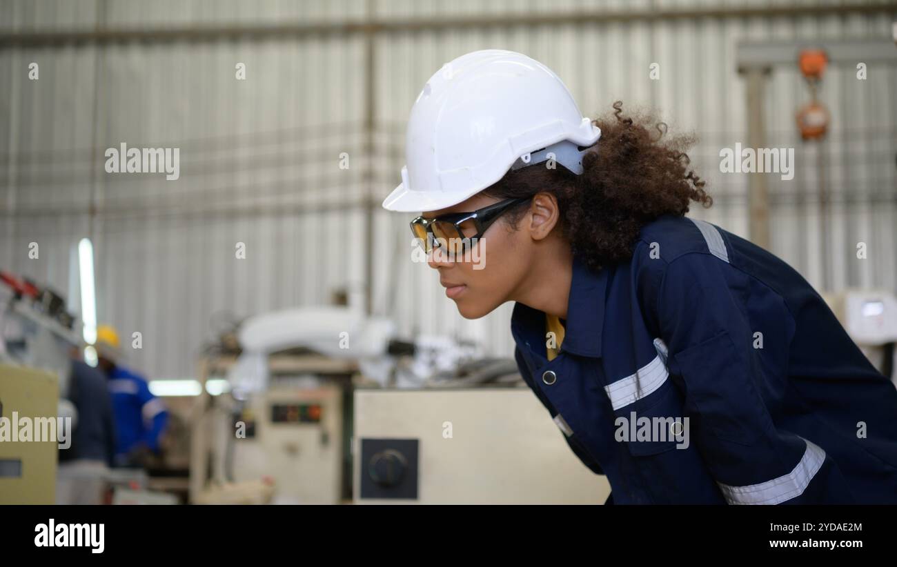 A young female worker is controlling a mechanical robot. Stock Photo