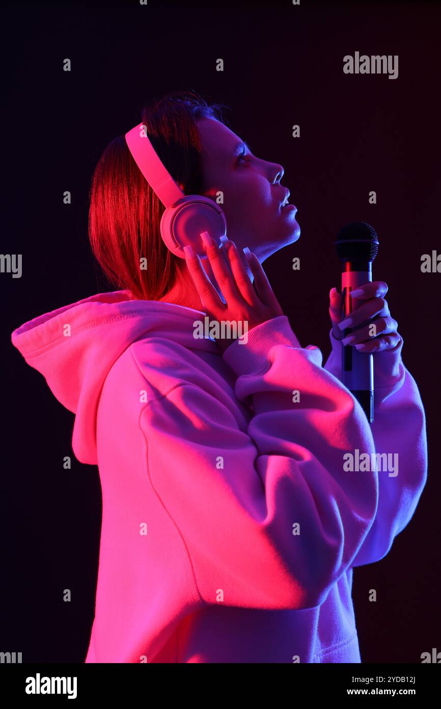 Singer Back Cool Cool female singer with microphone and headphones on dark background ...