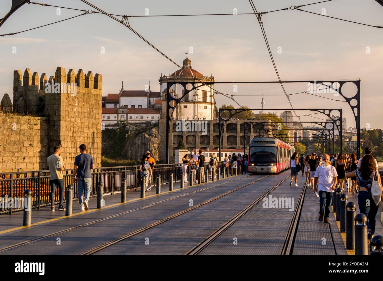 The Metro light rail line on the The Dom Luís I Bridge and the Walls of Dom Fernando or Fernandine Walls, Douro River, Porto, Portugal. Stock Photo