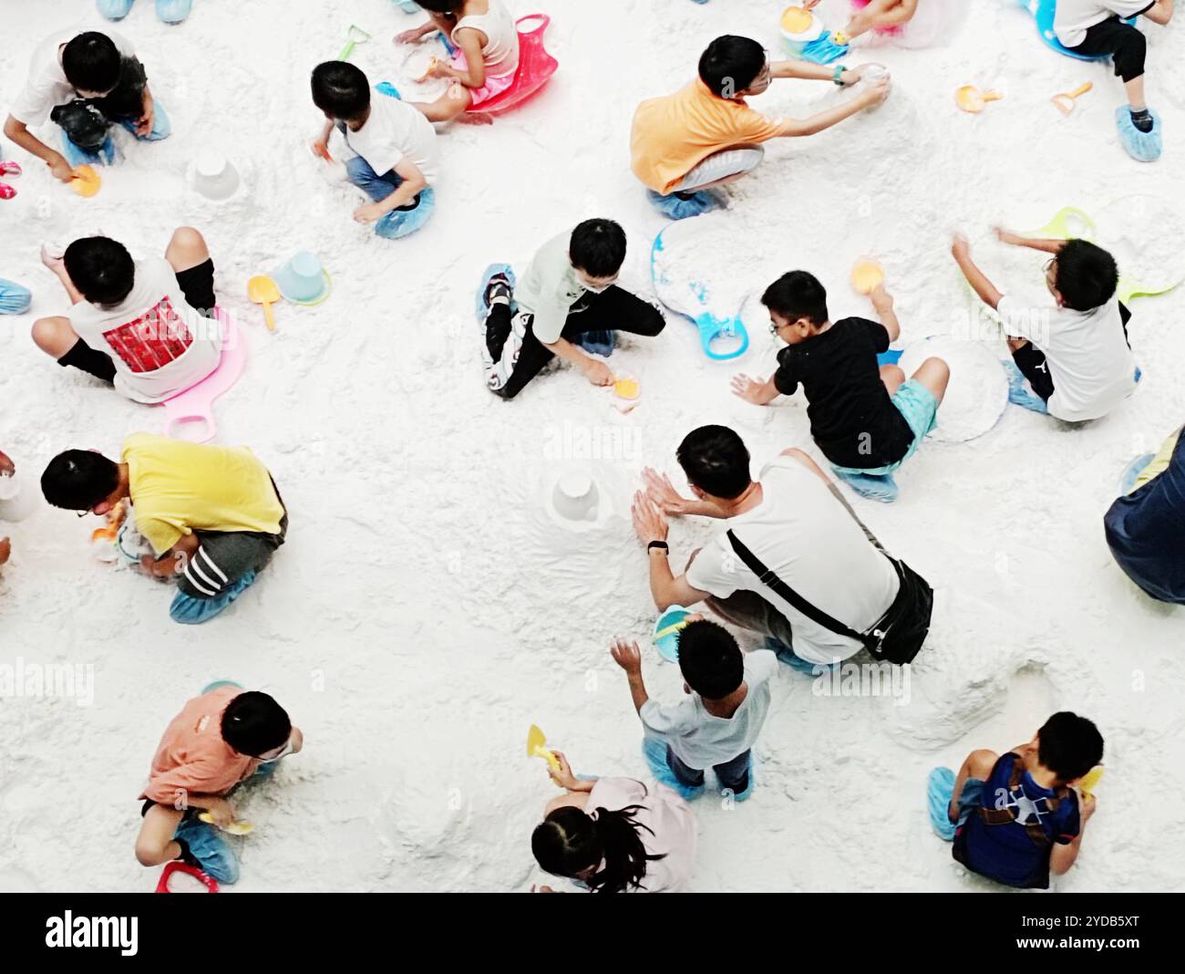 Kaohsiung, Taiwan - July 2, 2024: Many children gathered together to play in the snow. Making a snow Stock Photo