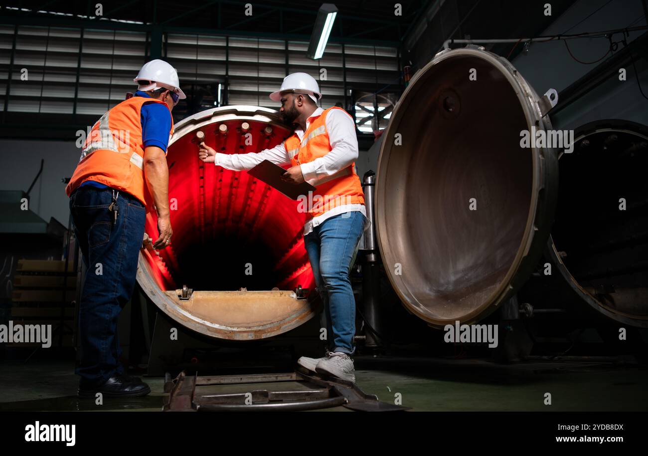 Chief engineer of a mechanical plant Inspecting and explaining the maintenance of the machine to the mechanic Stock Photo