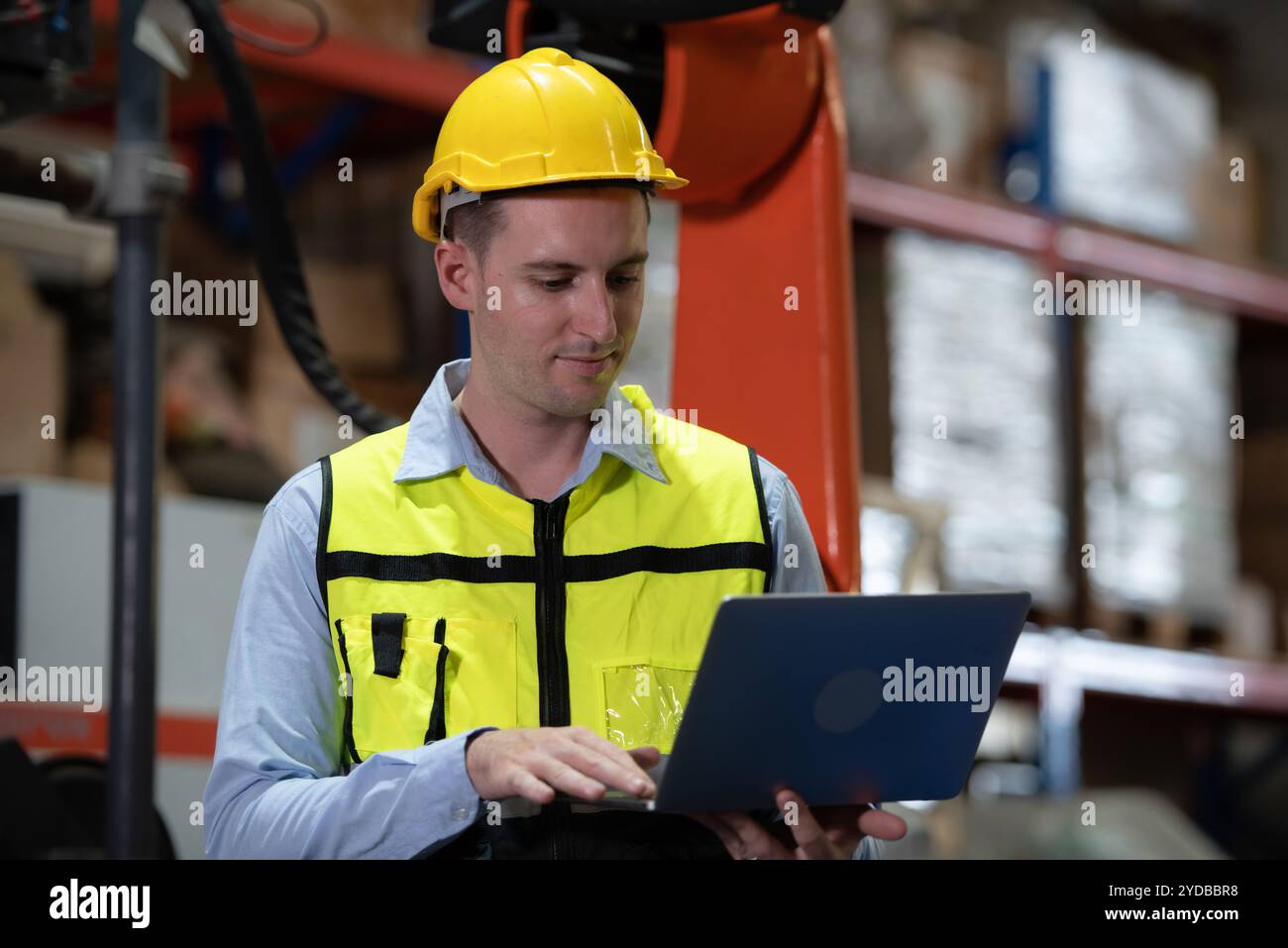 A male engineer checking the operation of a welding robot. used for precision welding control Fast and highly secure Stock Photo