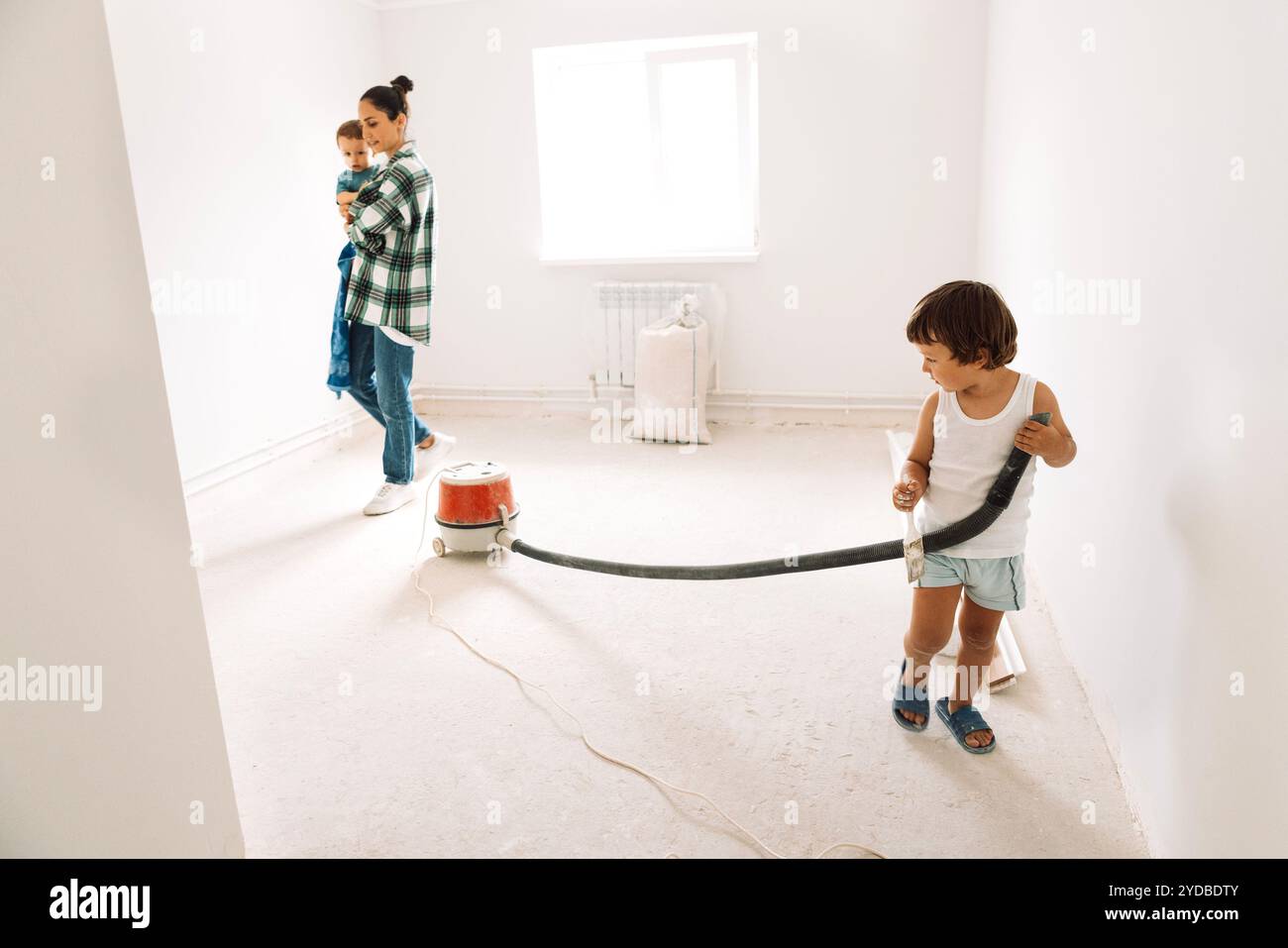 Little cute boy and his mother and brother with construction vacuum ...