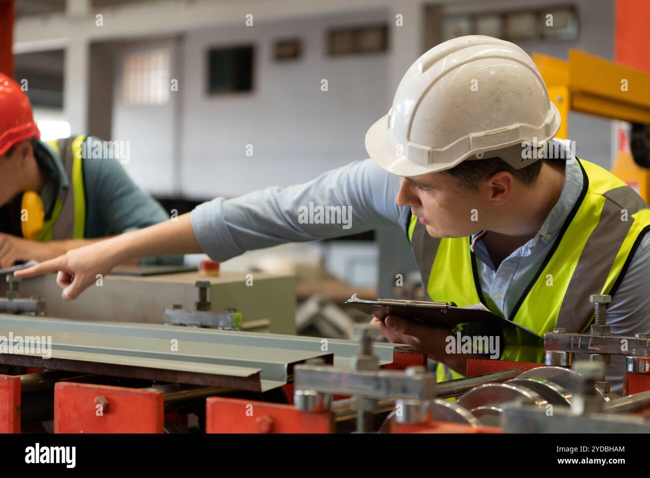 Two young engineers Testing and verifying the operation of the machines ...