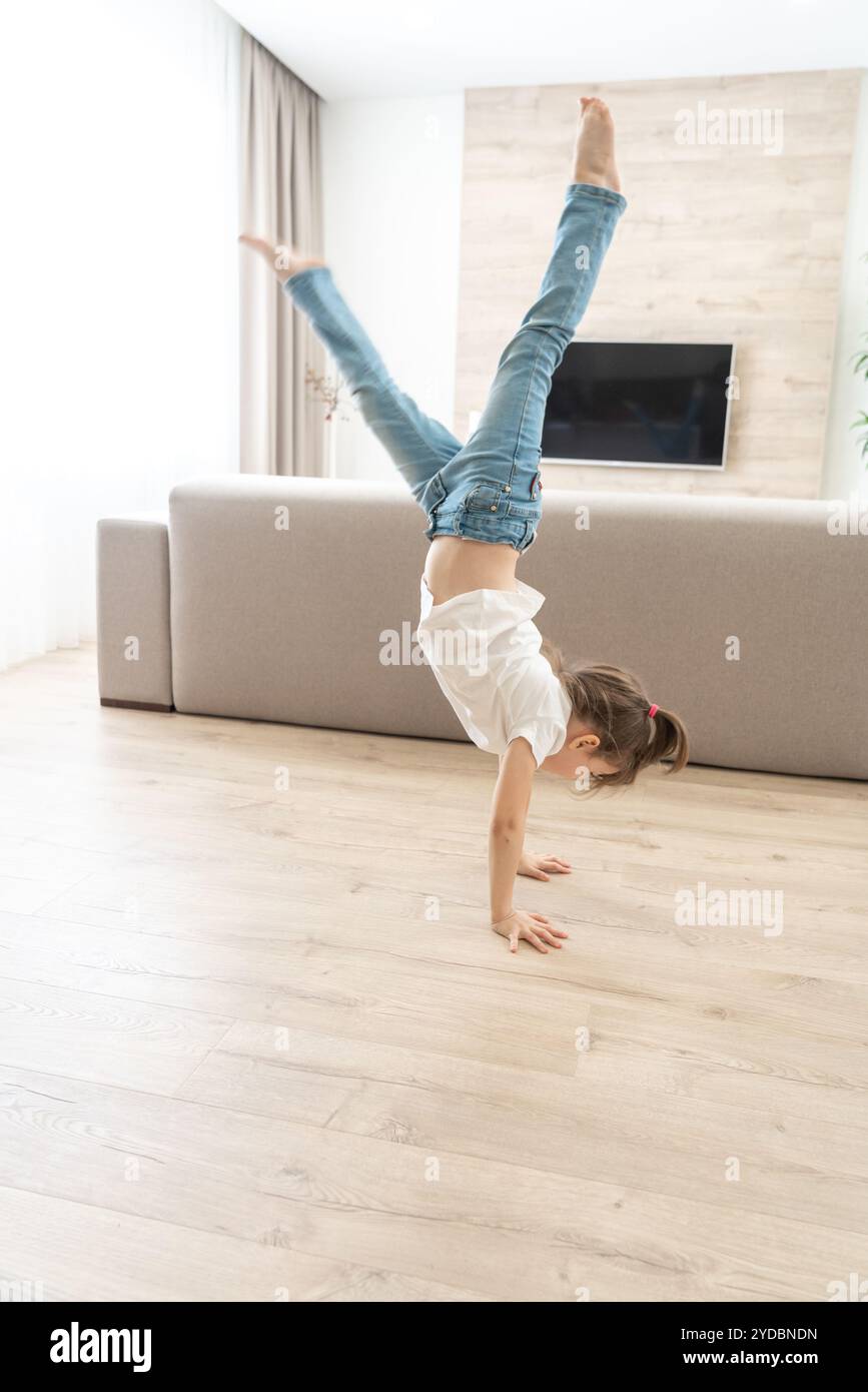 Girl standing upside down on her arms at home Stock Photo - Alamy