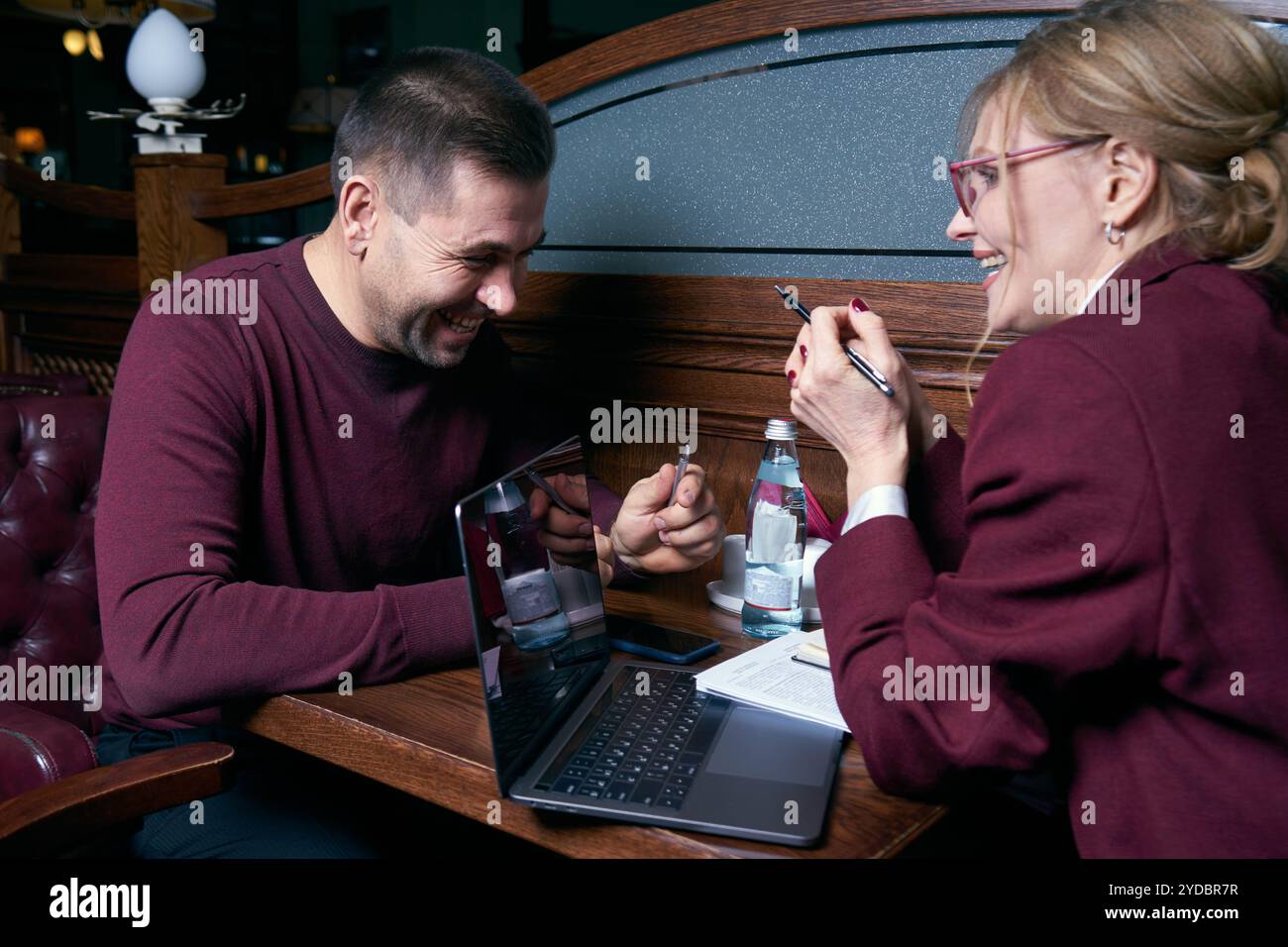 Happy business people working together on laptop in a restaurant Stock Photo