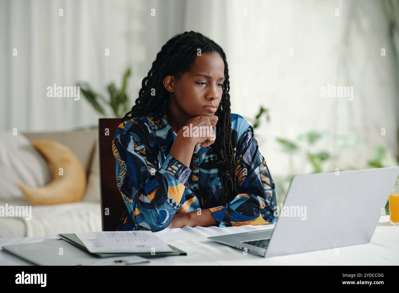 Contemplating Work at Desk with Laptop and Documents Stock Photo