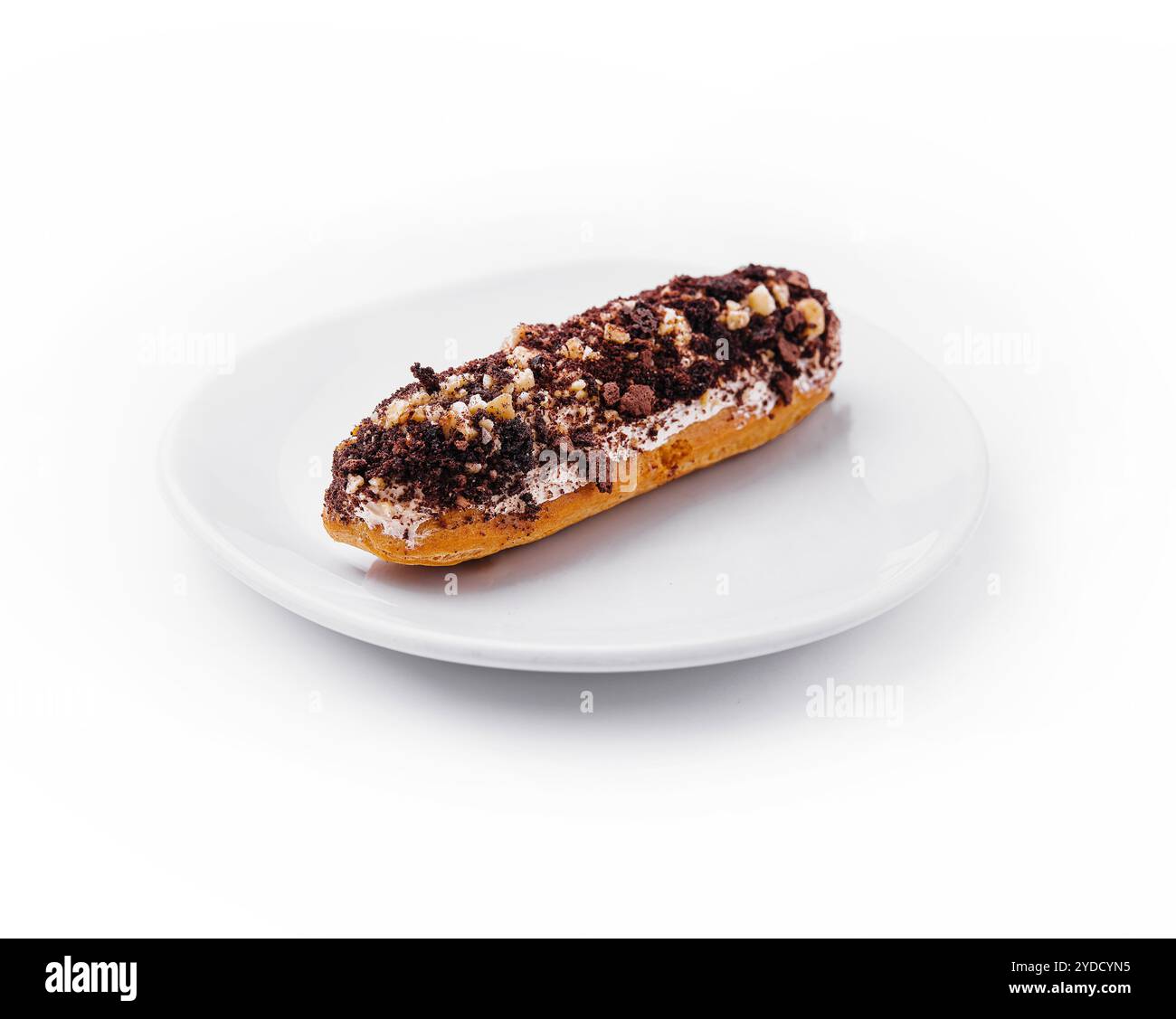 Eclair with chocolate and nuts on a white plate Stock Photo