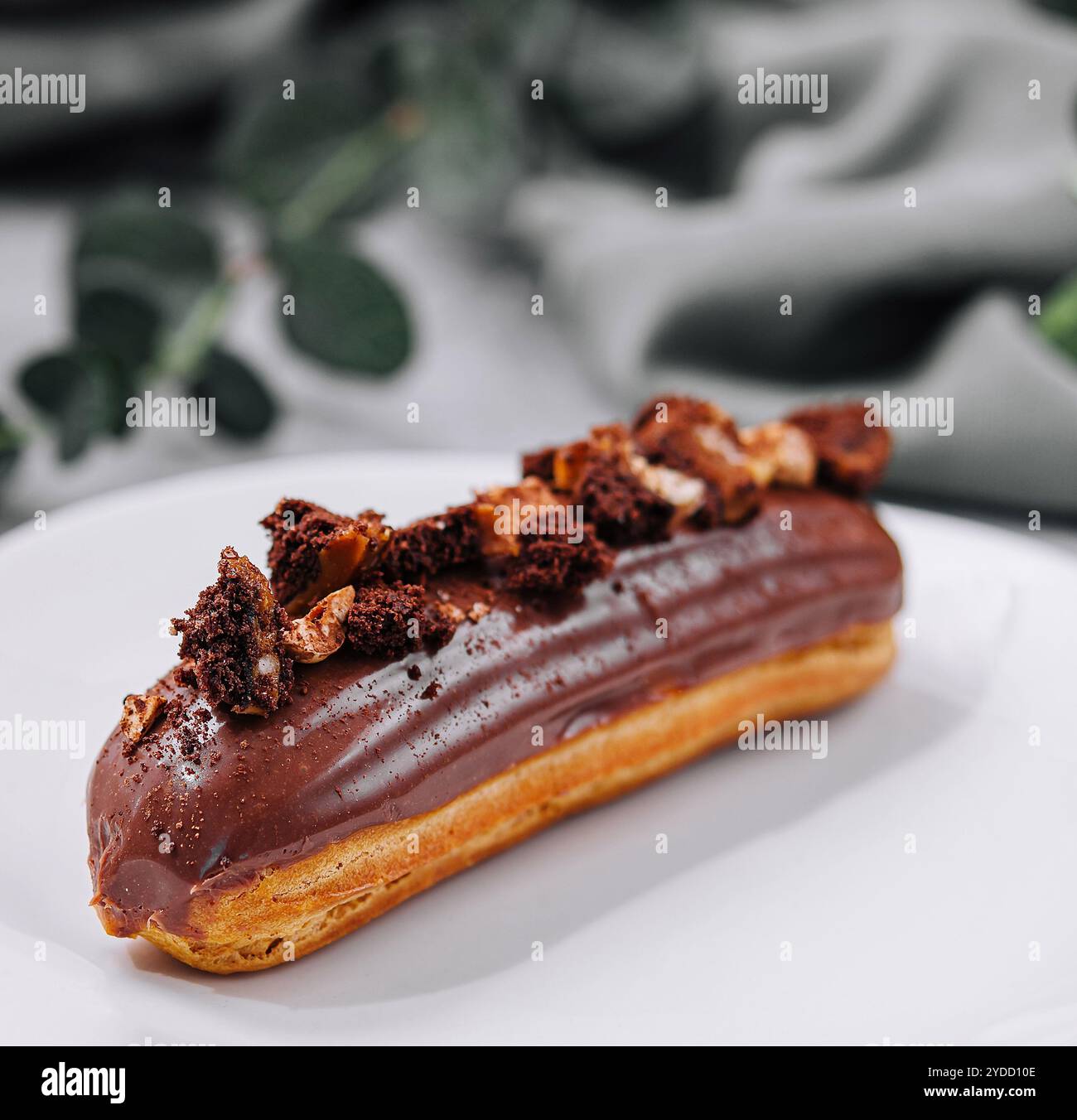 Eclair with Chocolate Cream and Hazelnuts Stock Photo