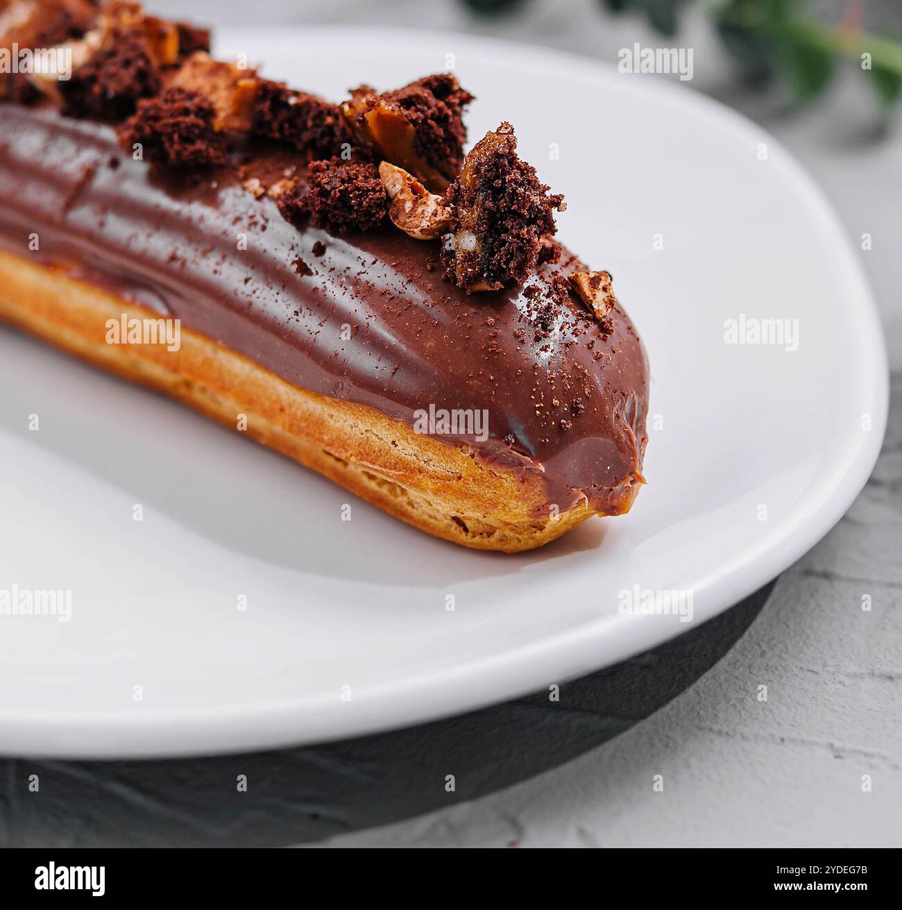 Eclair with Chocolate Cream and Hazelnuts closeup Stock Photo