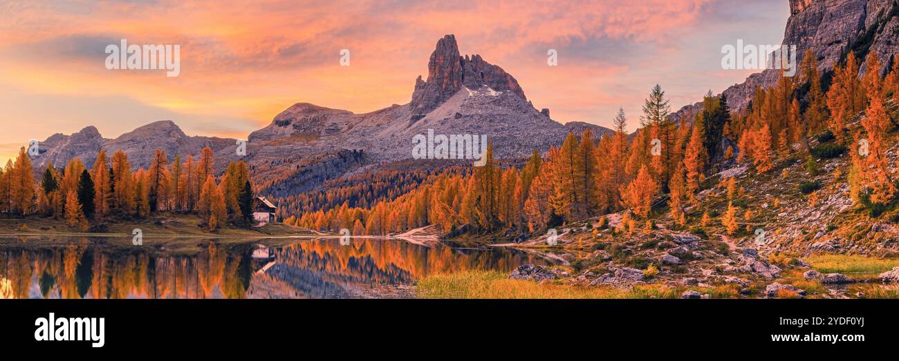 A wide 3:1 panoramic autumn sunrise in the Dolomites at Lago Federa (Lago di Federa, Lago Fedèra, Lake Federa), a mountain lake beneath the eastern wa Stock Photo