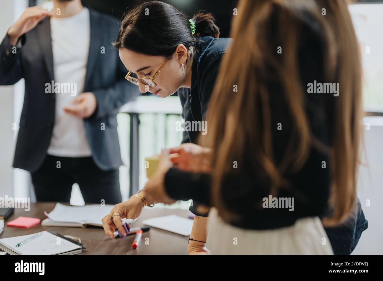 Students collaborating on academic project with supportive professor Stock Photo