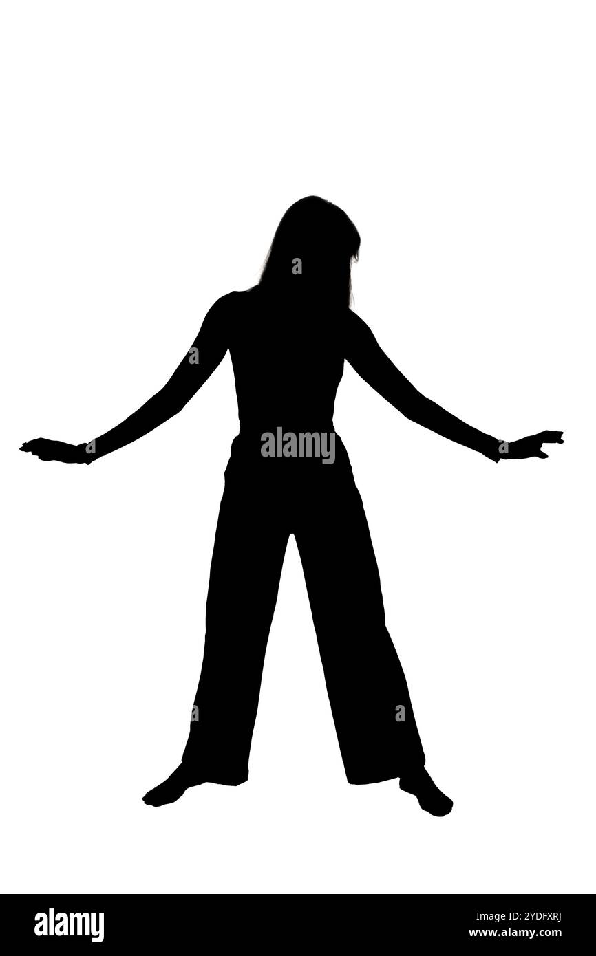 A striking silhouette of a woman elegantly standing with her arms ...