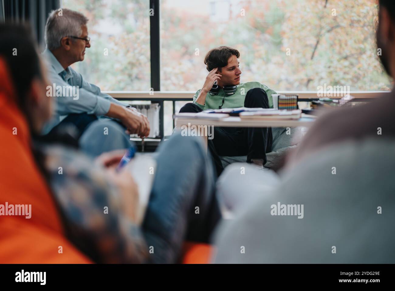 Professor engaging with students in casual classroom setting Stock Photo