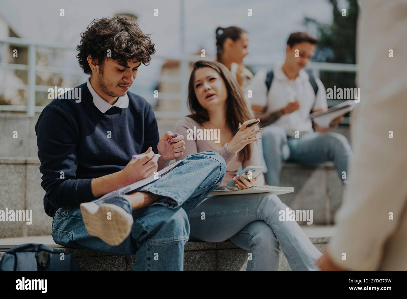 High school students collaborating with professor outdoors Stock Photo