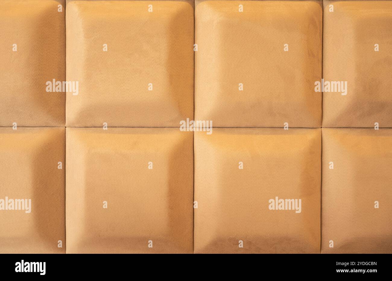 Background of Velvet Fabric Upholstery Panel with 3D Squares, Bed Headboard, Modern Luxury Quilted Velvet. Ochre Color. Stock Photo