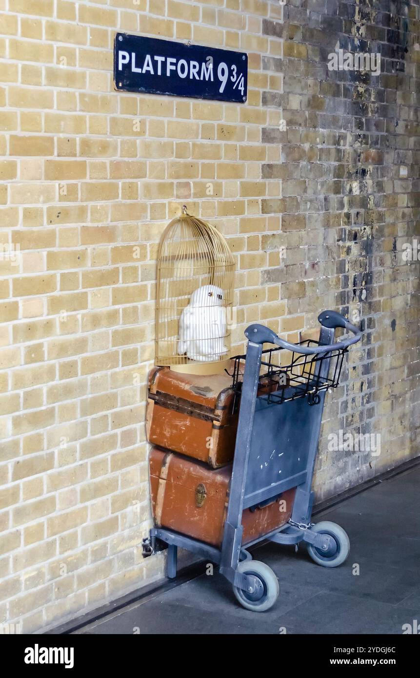 LONDON - MAY 31: Kings Cross station wall visited by fans of Harry Potter to photograph sign for platform nine and three quarters with trolley, London Stock Photo