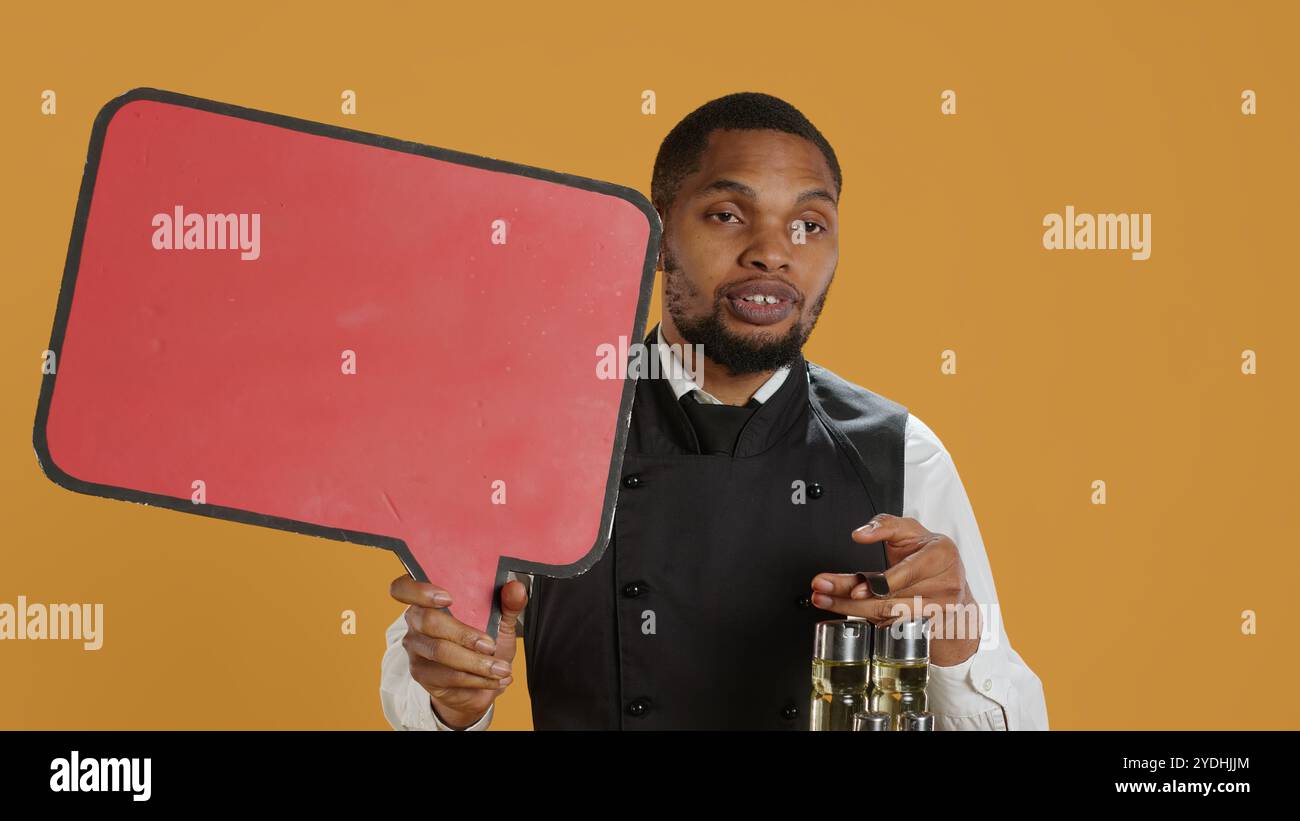 Catering employee showing a red speech bubble icon in studio, carrying ...