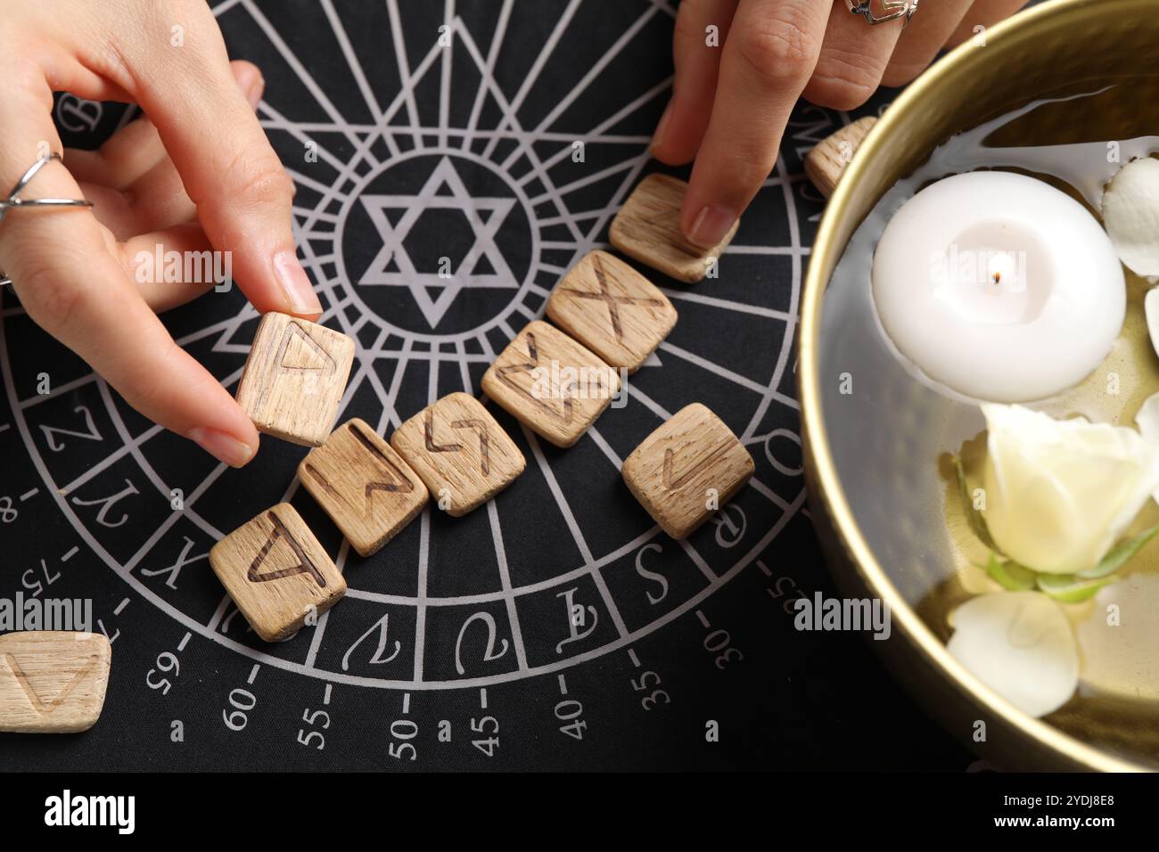 Woman with wooden runes at divination mat, top view Stock Photo - Alamy