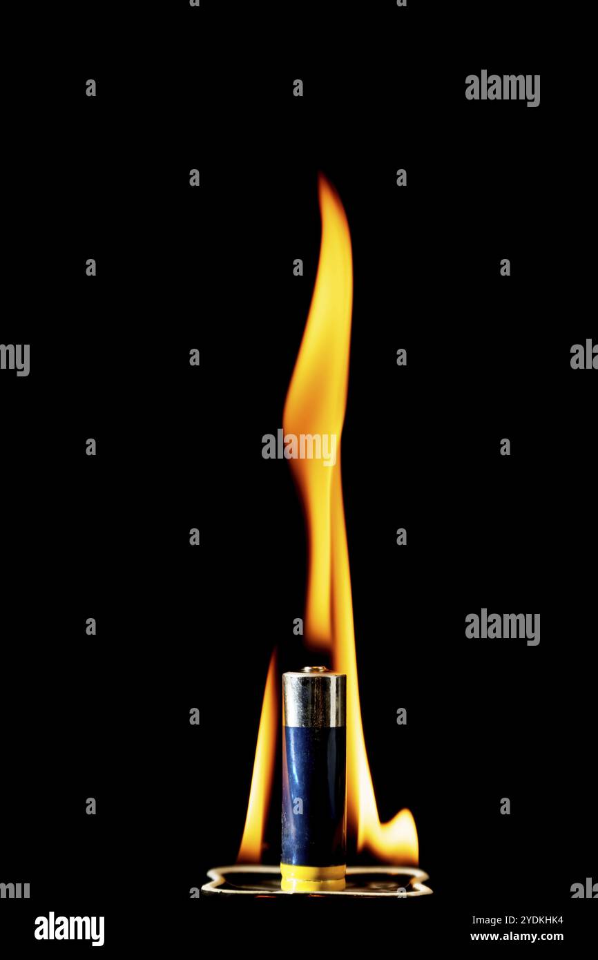 Lithium battery burning in fire isolated on black background with copy