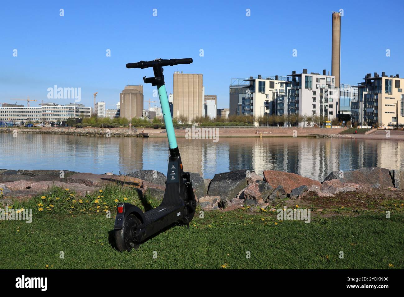 Tier electric scooter or e-scooter in scenic seaside park in Eira, with view to the modern architecture of Hernesaari, Helsinki, Finland. May 23, 2020 Stock Photo