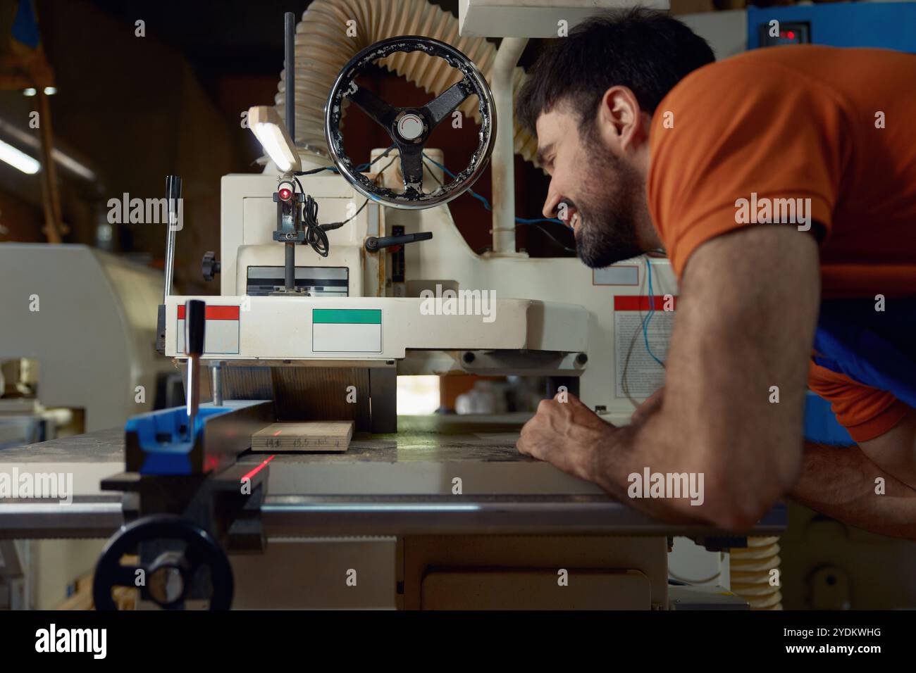 Woodworker using planer machine for production wooden materials specific size Stock Photo