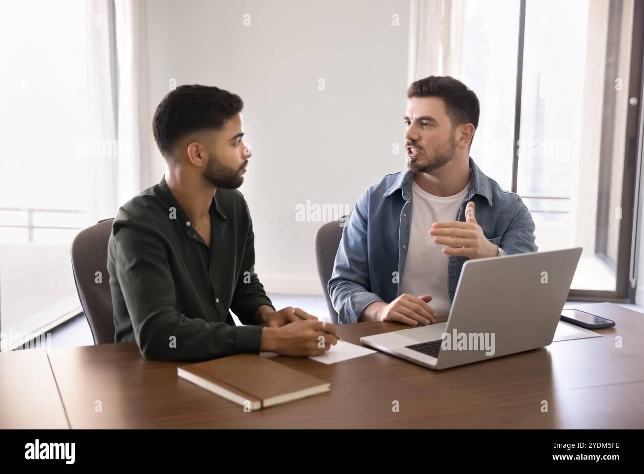 Confident engaged young Arabic business partners working on online startup Stock Photo