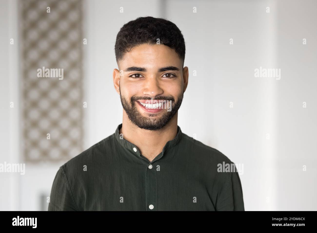 Happy handsome young Arabic businessman posing for head shot Stock Photo