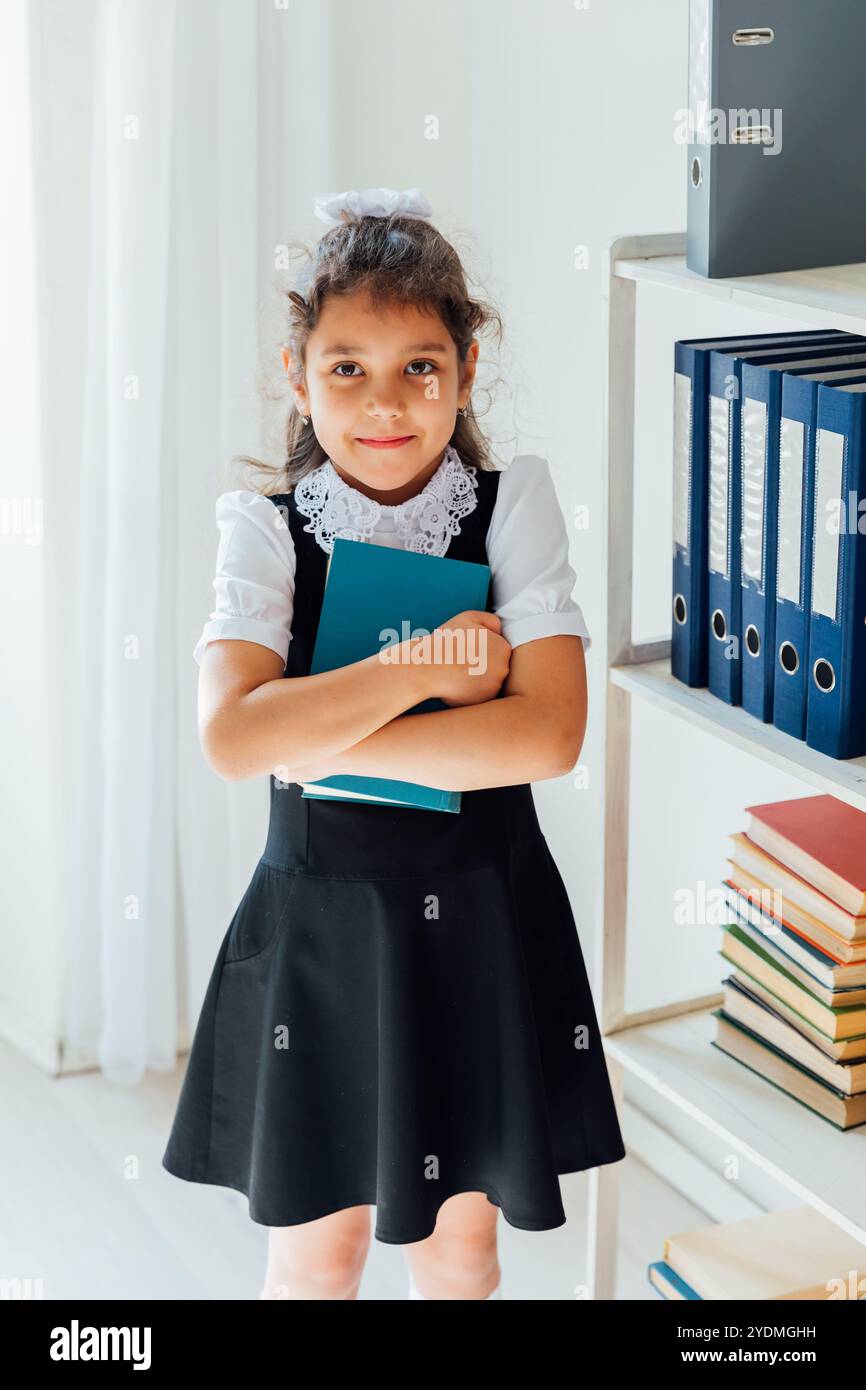 Schoolgirl holding a book in her hands in library classroom Stock Photo ...