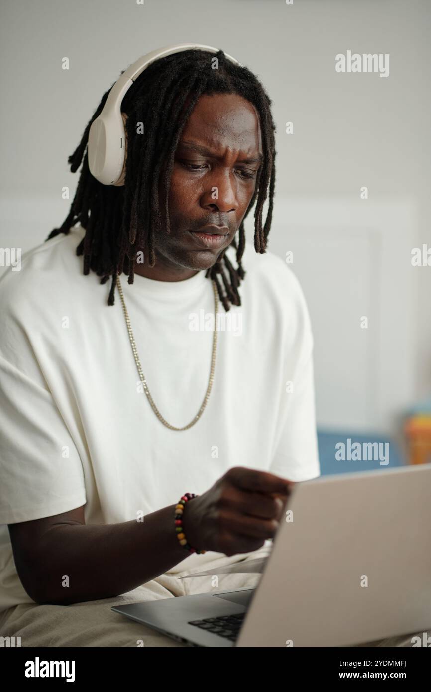 Focused Man Using Laptop with Headphones On Stock Photo