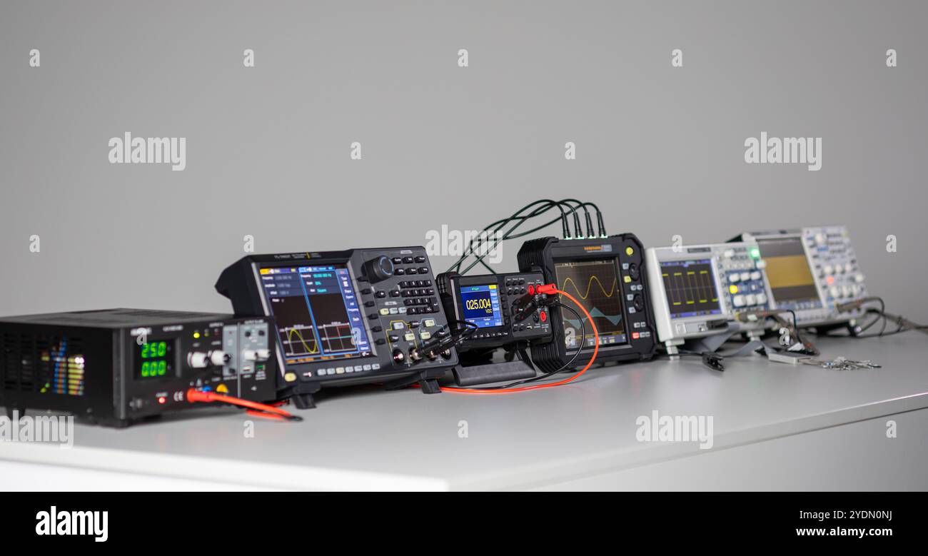 Various measuring devices and oscilloscopes set up on a work table in a work situation Stock Photo