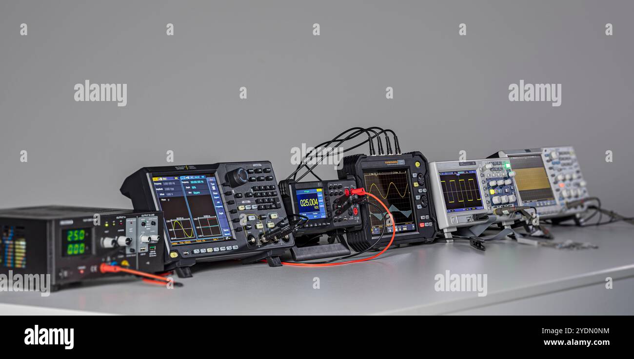Various measuring devices and oscilloscopes set up on a work table in a ...