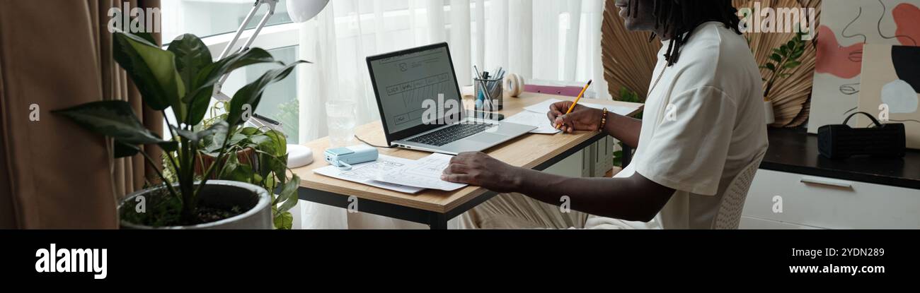 Focused Man Engaging in Remote Work at Home Office Stock Photo