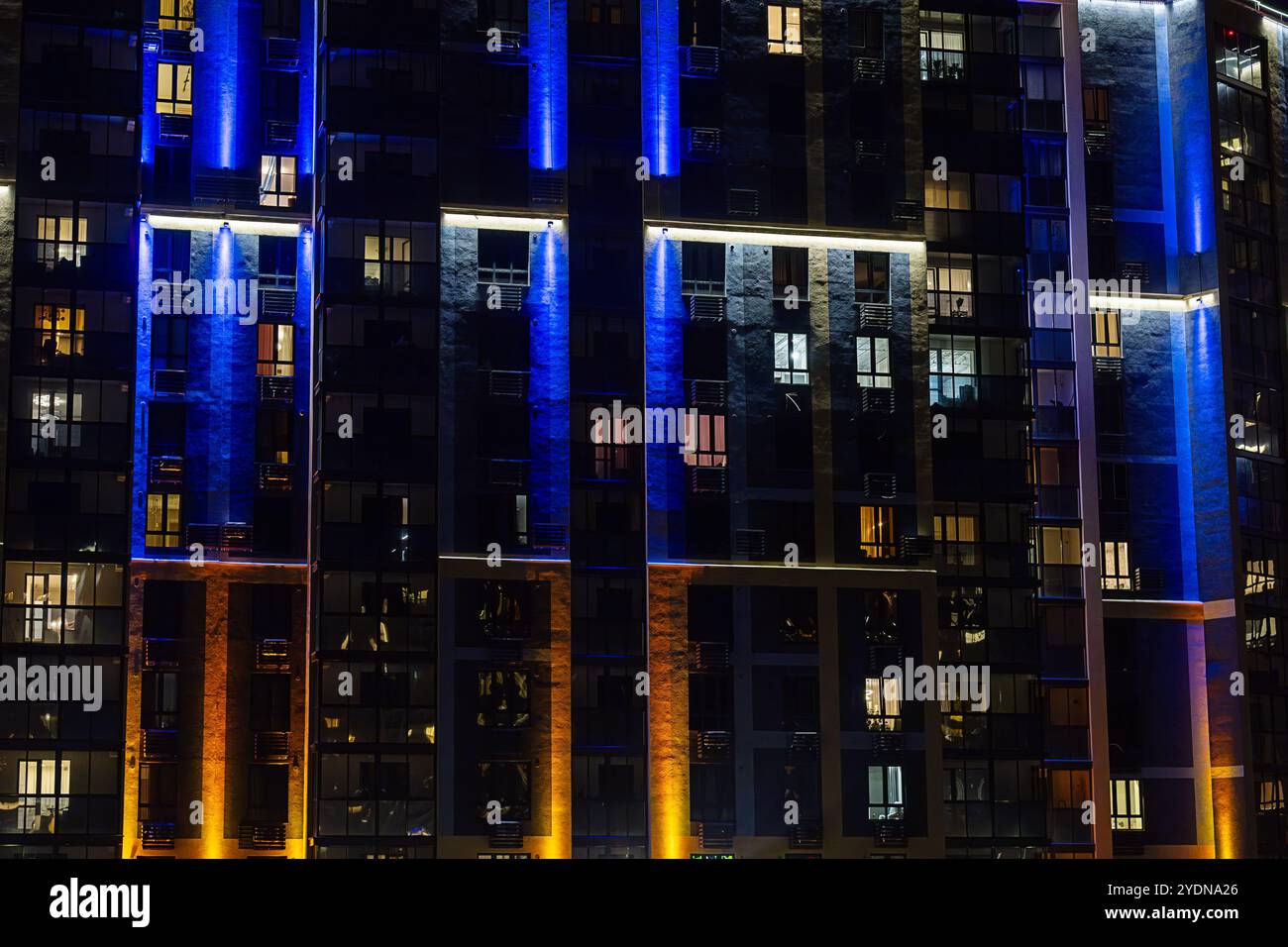 Image showcasing Modern apartment building facade illuminated with vibrant lights at ...