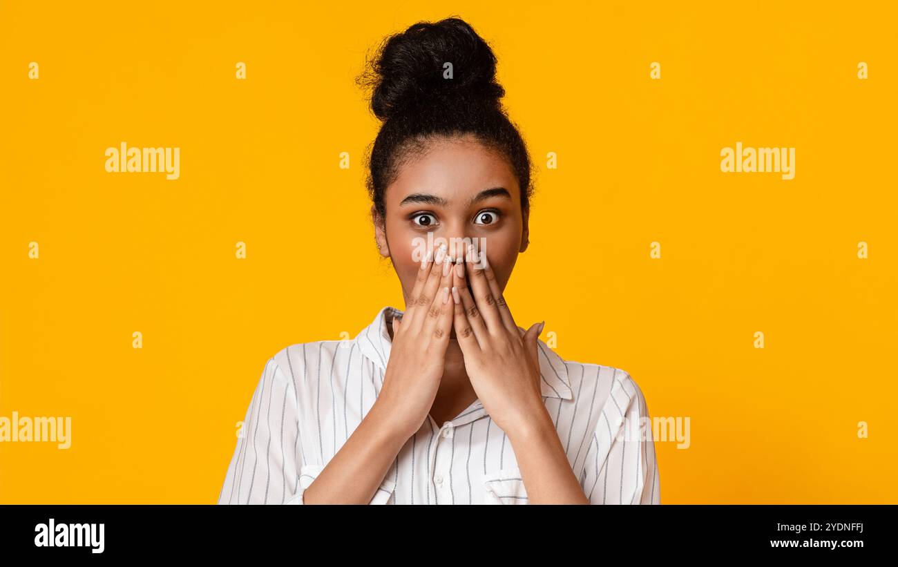 No way. Shocked black girl covering mouth with hands in amazement Stock Photo