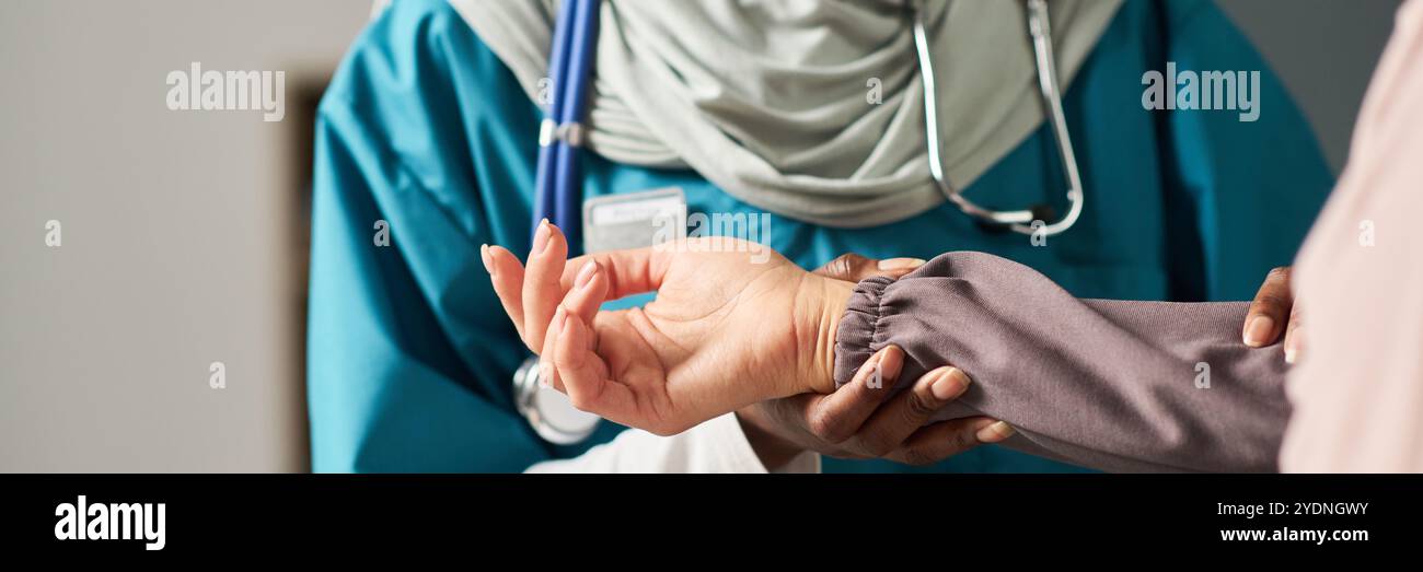 Muslim Nurse In Scrubs Feeling Patient Pulse During Routine Checkup muslim-nurse-in-scrubs-feeling-patient-pulse-during-routine-checkup