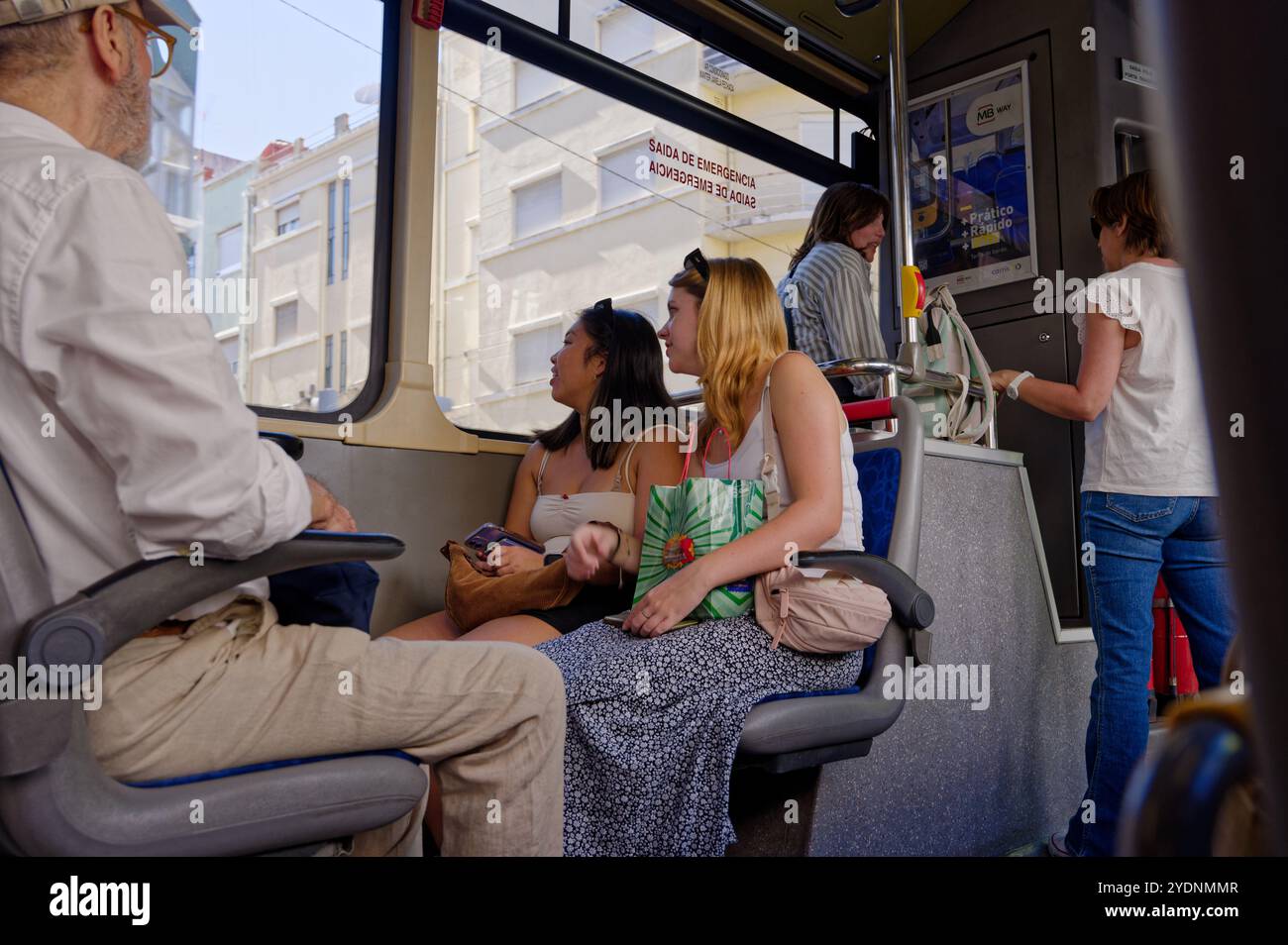 Passengers sharing a relaxed moment on a Lisbon bus, taking in the city sights together Stock Photo