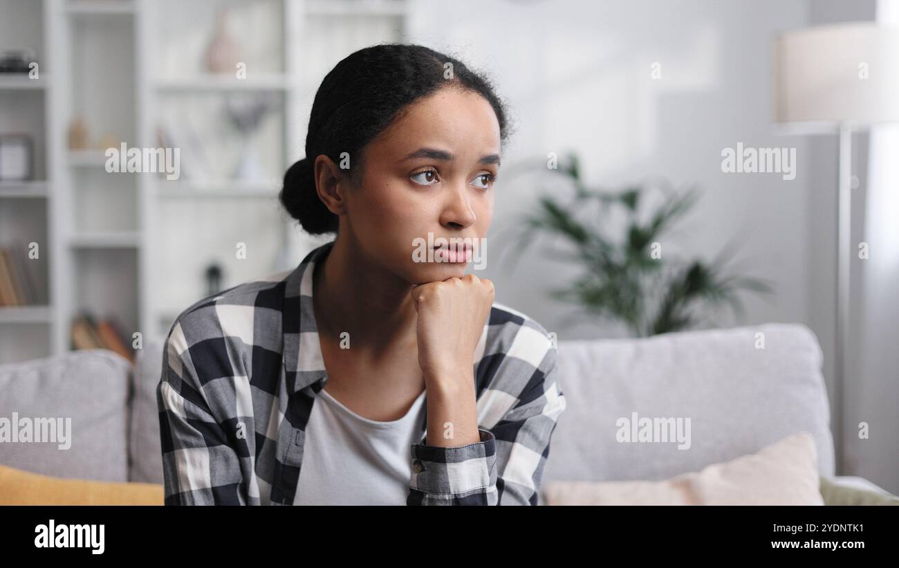Attractive African American girl sitting in living room, resting Stock ...