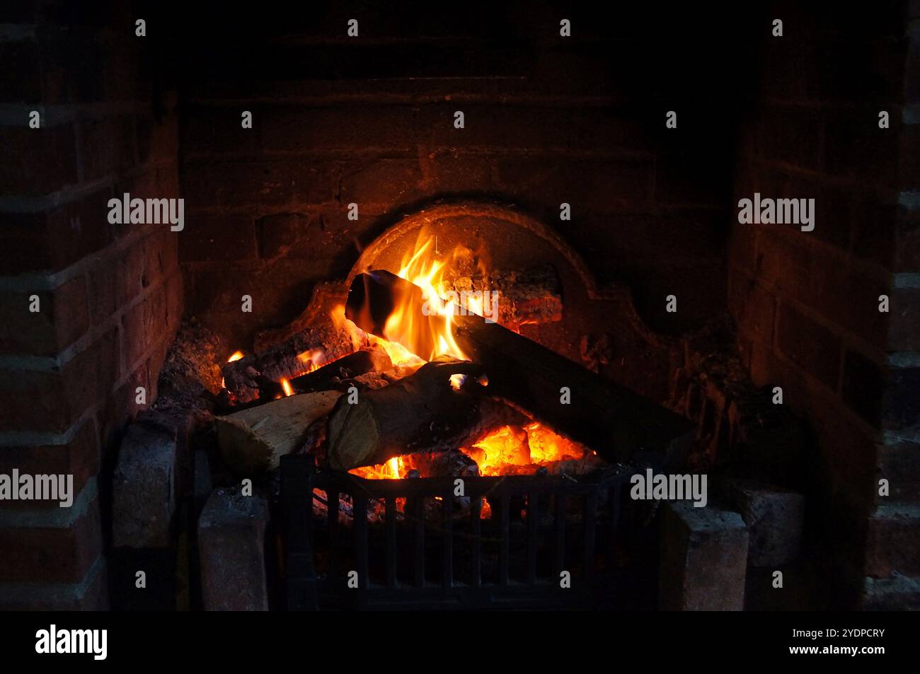 Close up a of a burning log fire in a brick fireplace Stock Photo - Alamy