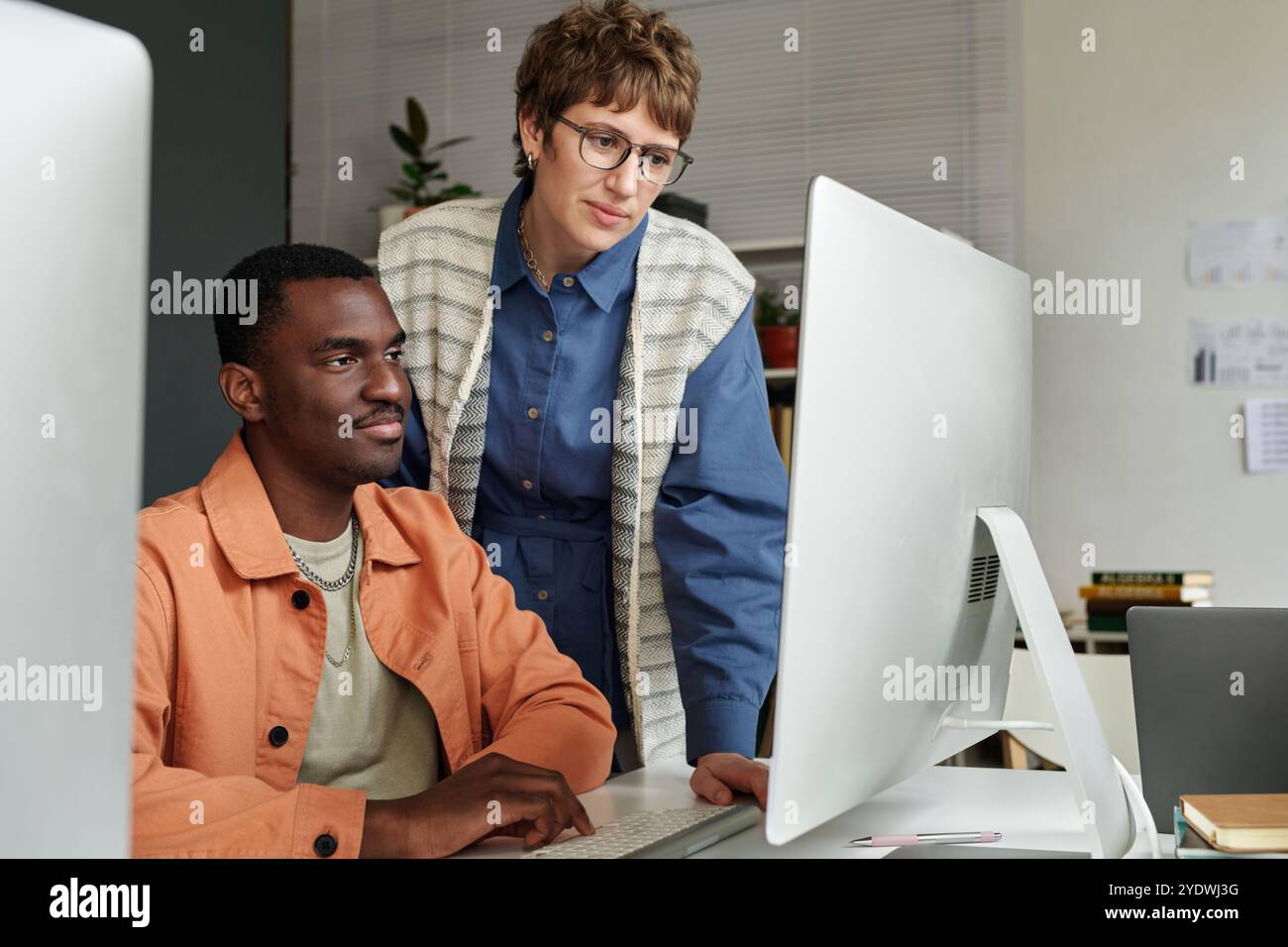 Collaborating on Computer Project in Office Environment Stock Photo